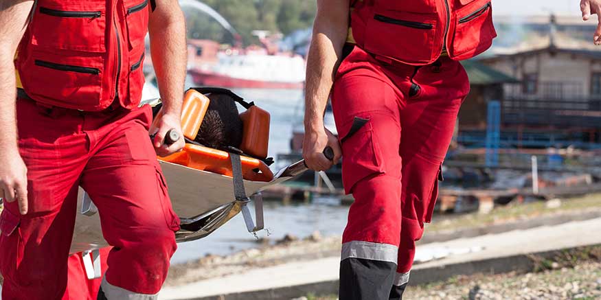 Rettungskräfte tragen verletzte Person auf einer Trage