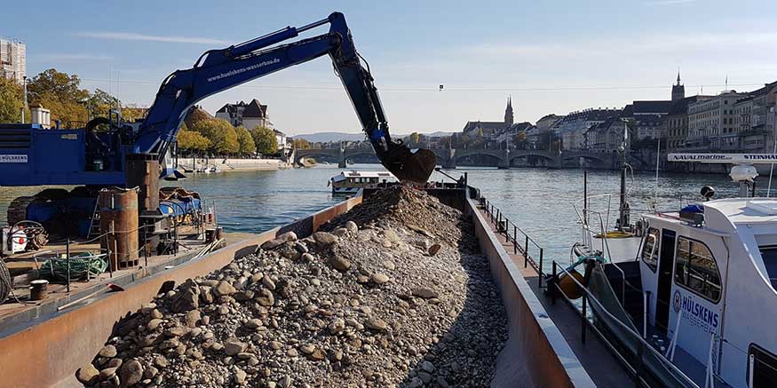 Binnenschiff wird von Bagger beladen