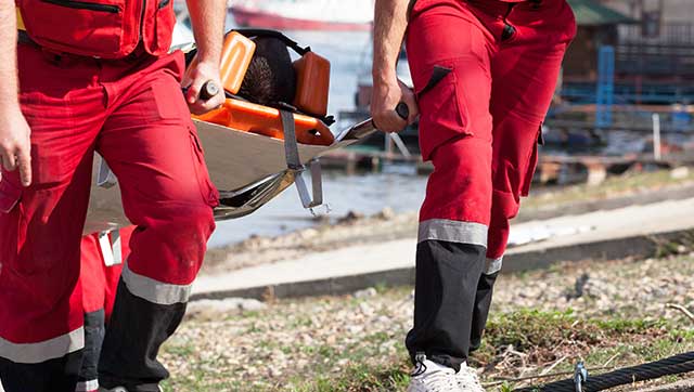 Rettungskräfte tragen verletzte Person auf einer Trage