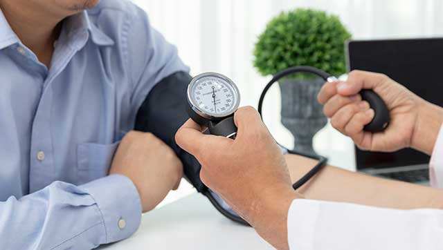 Arzt misst Blutdruck einer Person
