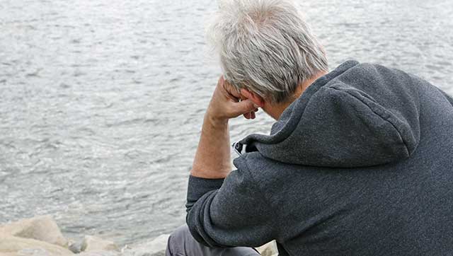 Mann blickt sorgenvoll auf Wasser