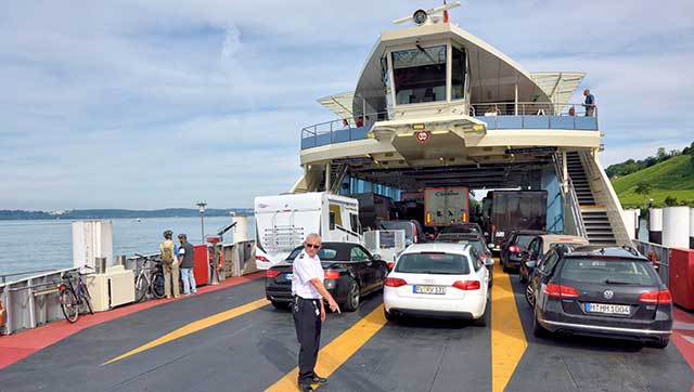 Besatzungsmitglied weist Pkws auf Fahrgastschiff ein