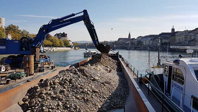 Binnenschiff wird von Bagger beladen