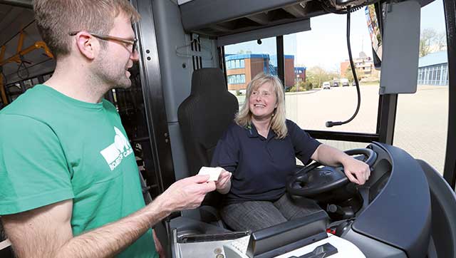 Busfahrerin übergibt Fahrschein an Fahrgast