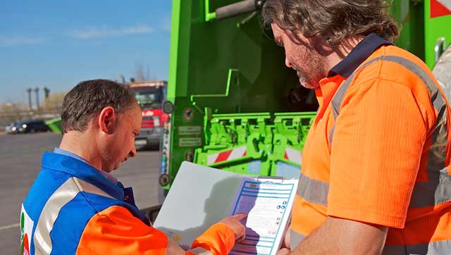 Zwei Männer in Arbeitskleidung schauen auf Checkliste