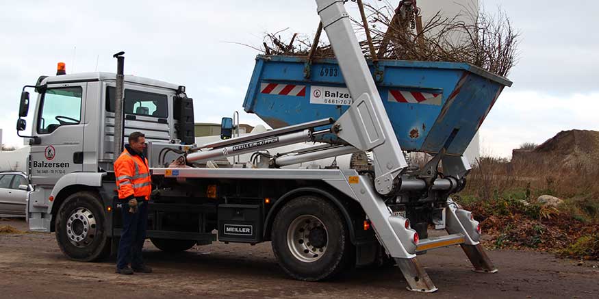 Container mit Baumschnitt wird abgekippt