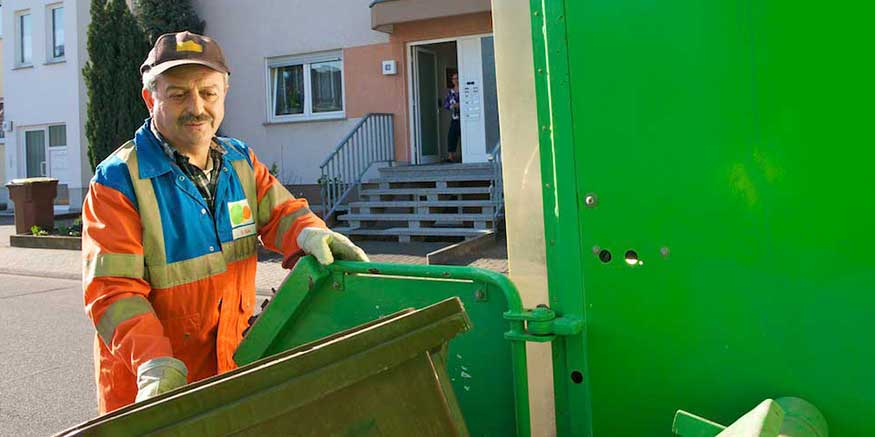 Müllwerker in PSA greift Tonne