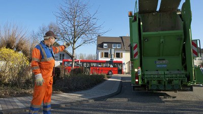 Rückwärtsfahrendes Abfallsammelfahrzeug mit Einweiser