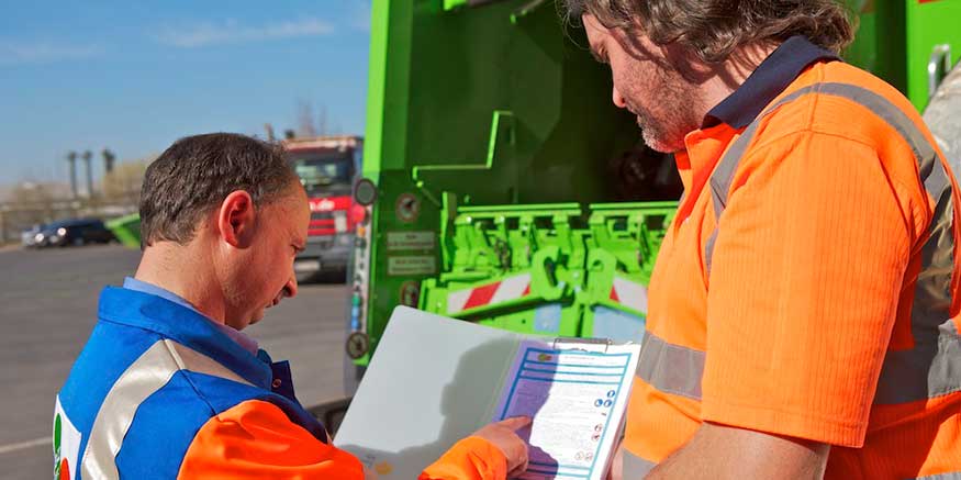 Zwei Entsorgungsmitarbeiter prüfen einen Checkliste