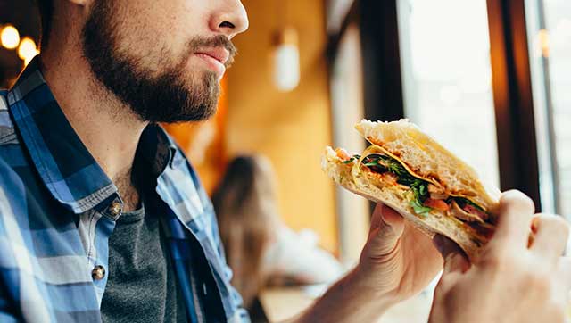 Mann hält Sandwich in der Hand