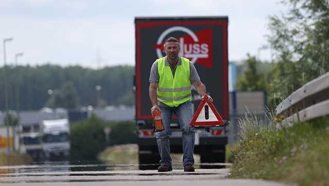 Lkw-Fahrer stellt Warndreieck auf