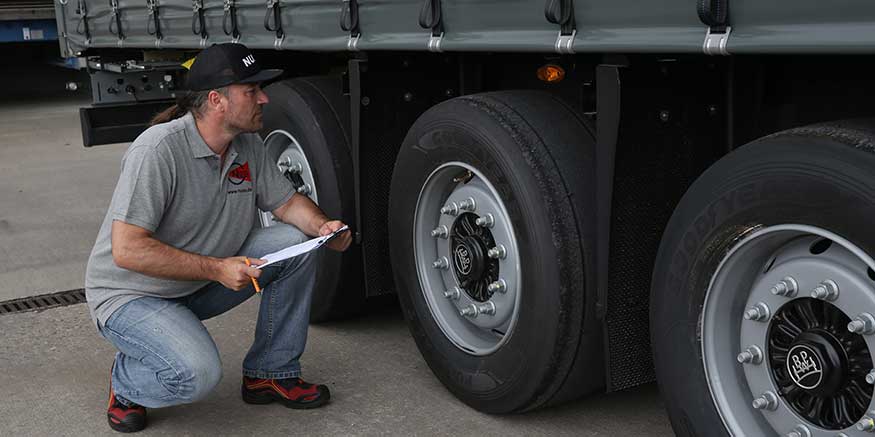 Fahrer kontrolliert Lkw-Reifen