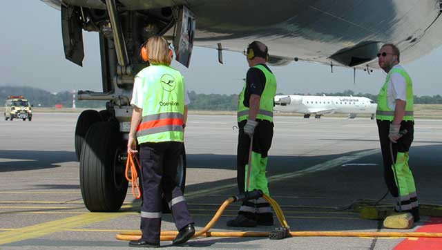 Beschäftigte mit Gehörschutz auf Flughafen-Vorfeld