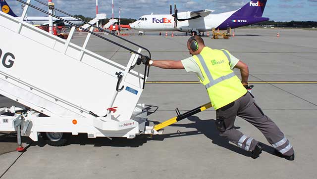 Flughafenmitarbeiter schiebt Gangway