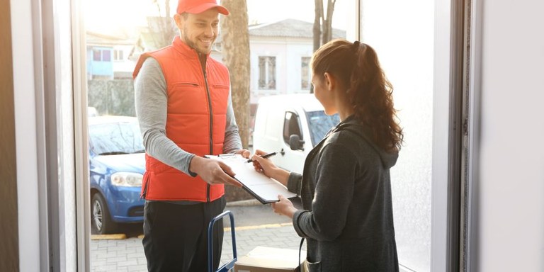 Paketbote liefert Paket an Haustür