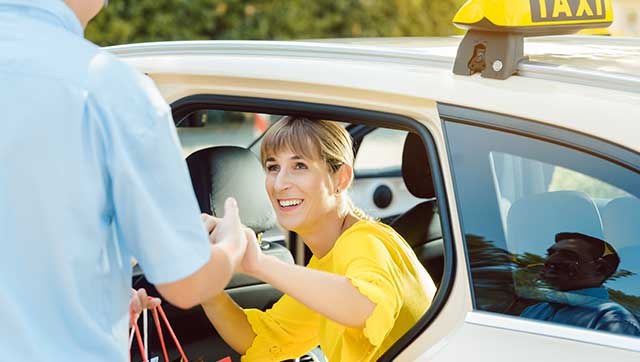 Taxifahrer hilft Frau beim Aussteigen