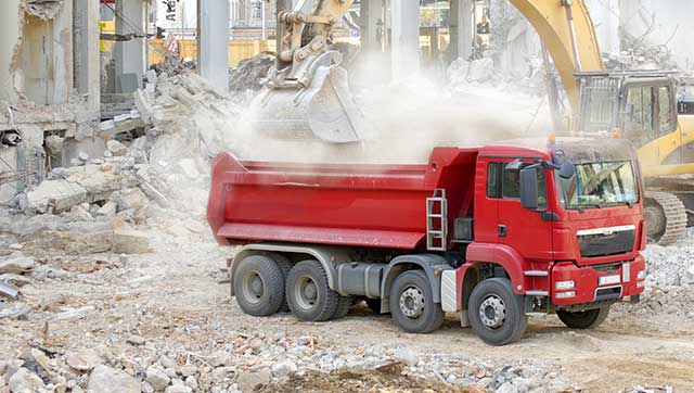 Staubwolke beim Beladen eines Lkw mit Bauschutt