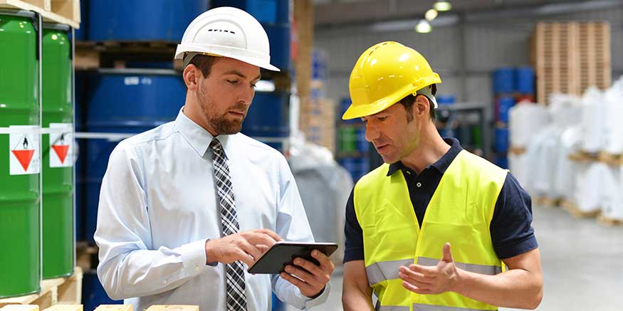 Chef und Mitarbeiter diskutieren mit Blick auf ein Tablet