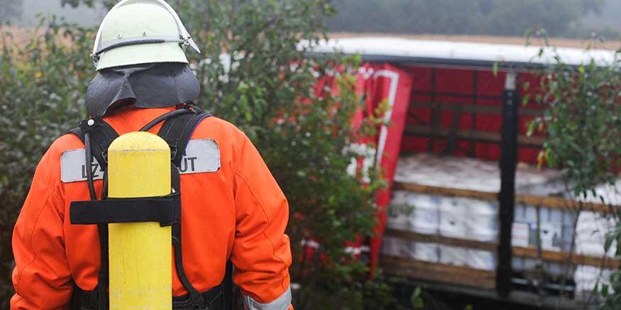 Feuerwehrmann blickt auf offene Lkw-Ladung