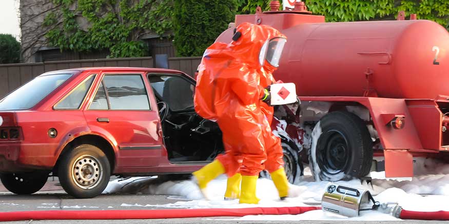 Feuerwehr in Schutzanzügen verteilen Löschschaum